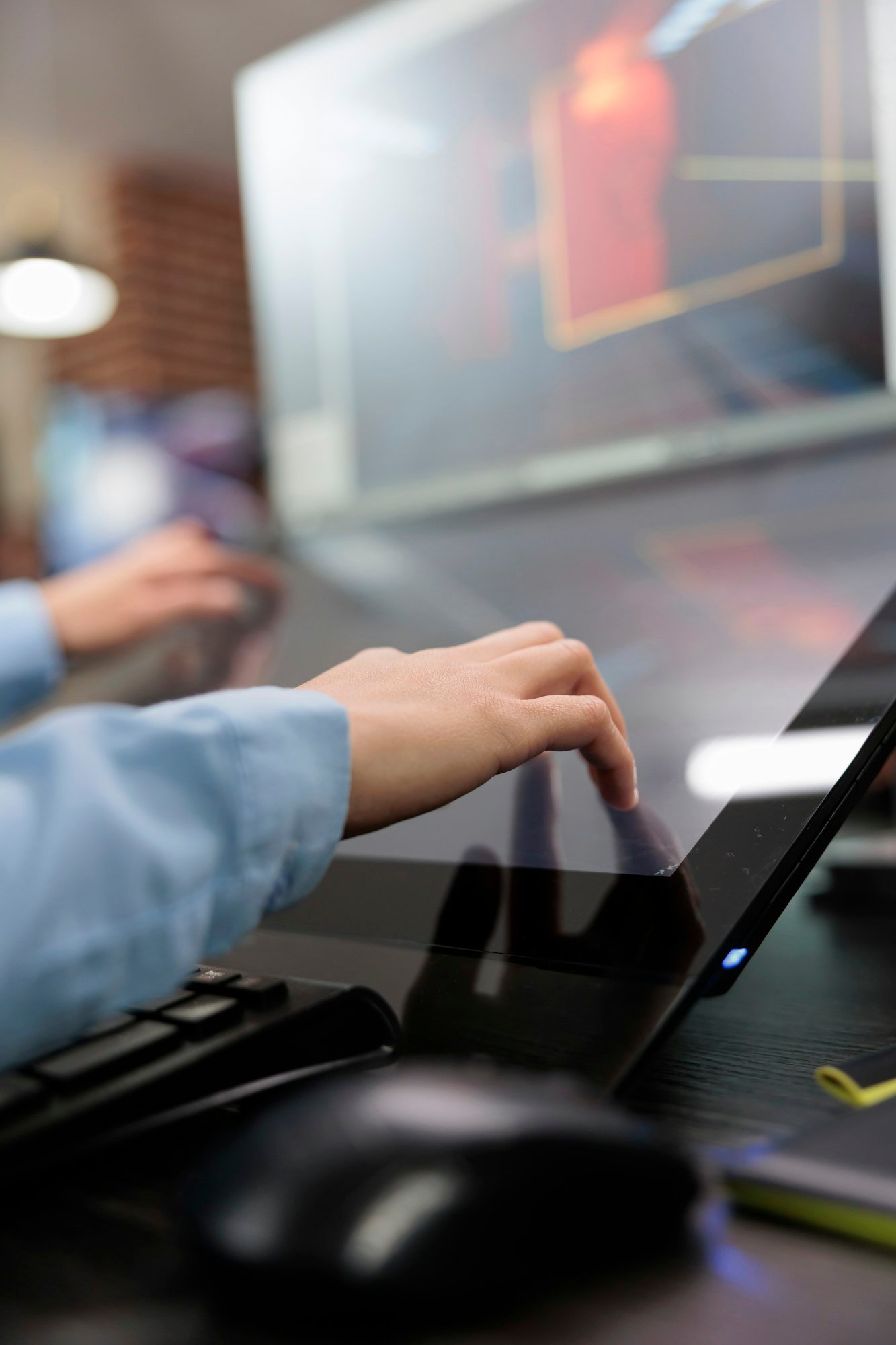 Close up of creative game creator hands on multiple modern displays while optimising videogame