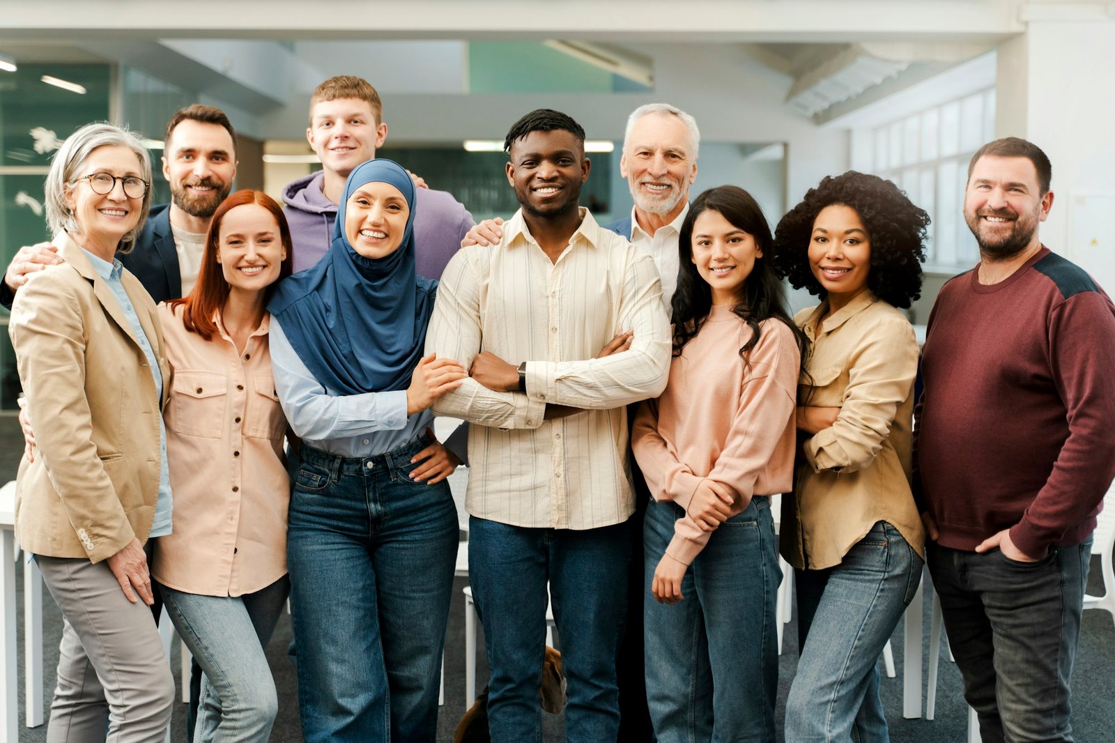 Group portrait of smiling multiracial business people looking at camera in modern office. Meeting