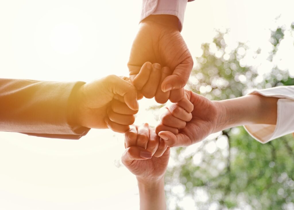 Hands of business people making fist bump together